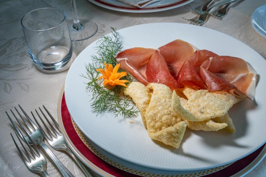 a white plate with food on a table at Hotel Biodola in Portoferraio