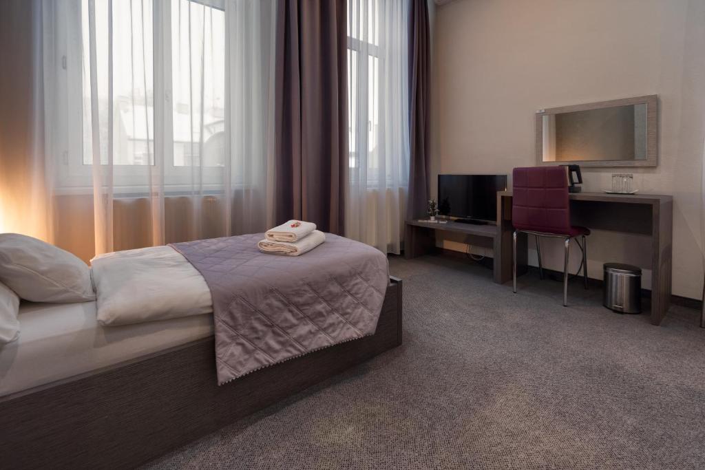 - une chambre avec un lit, un bureau et une télévision dans l'établissement Penzión Sport, à Košice