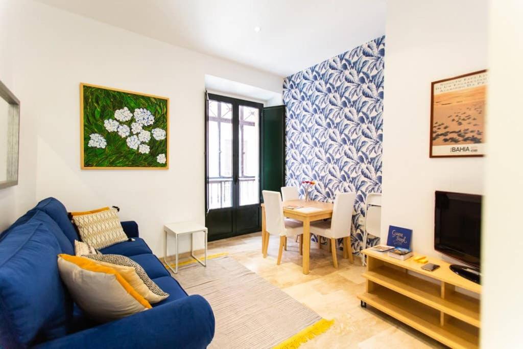 a living room with a blue couch and a table at Cheap & Chic in the center of Sevilla in Seville