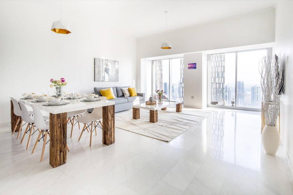 a white living room with a table and a couch at Frank Porter - Cayan Tower in Dubai