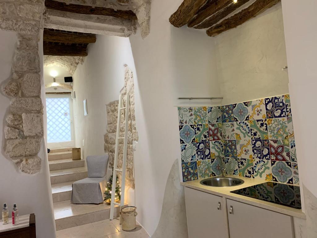 a bathroom with a sink and a mosaic tile wall at Dimora Le Zagare in Ostuni