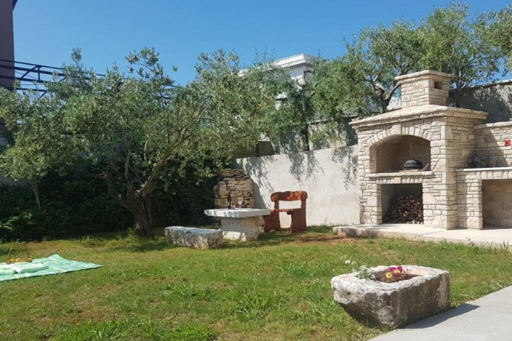 a garden with a stone oven in the grass at Apartment Lino in Premantura