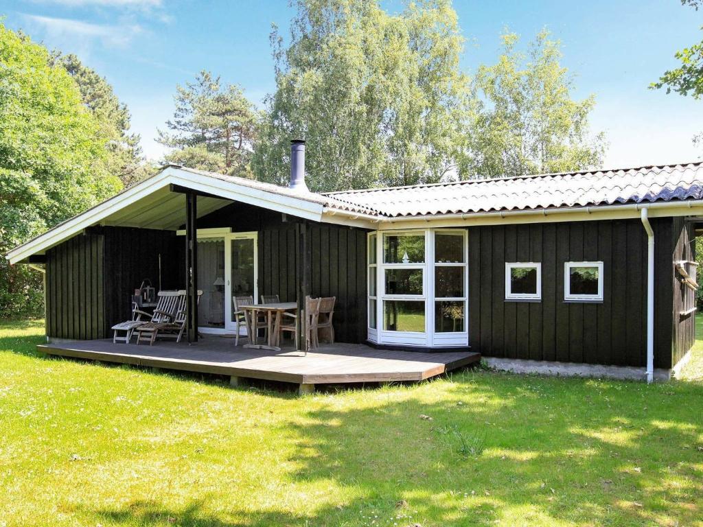 een zwart huis met een veranda en een patio bij 5 person holiday home in G rlev in Gørlev