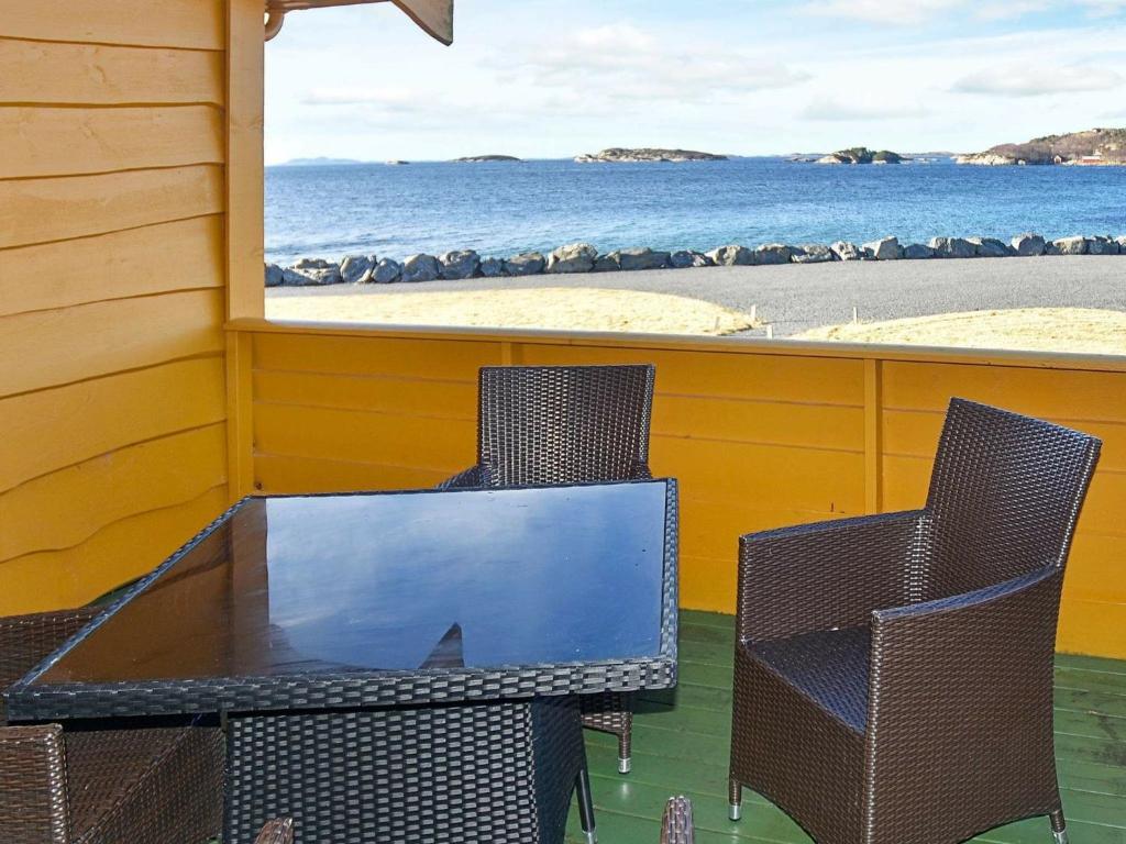 ein Tisch und Stühle auf einer Veranda mit Blick auf den Strand in der Unterkunft 6 person holiday home in Aukra in Aukra