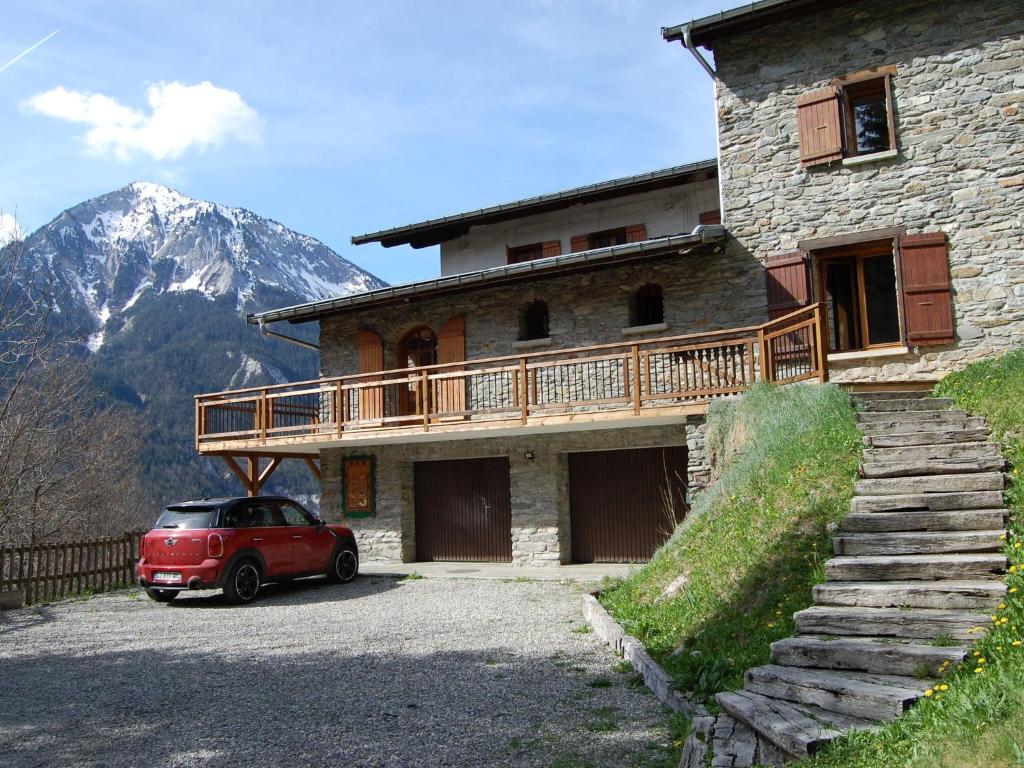 Le VillardにあるMagnificent chalet with saunaの建物前に停車する赤い車