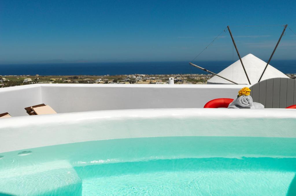 a person sitting in a chair next to a swimming pool at Drops Villas in Vóthon