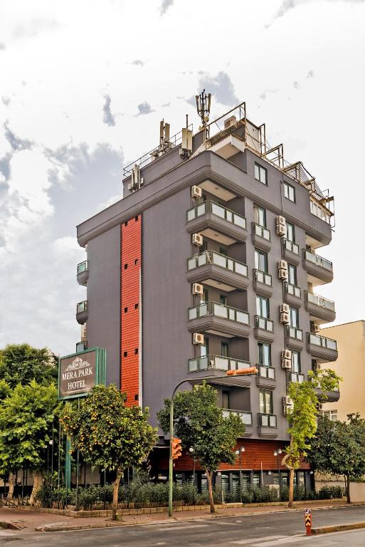 a tall grey building with a street sign in front of it at Mera Park Hotel in Antalya