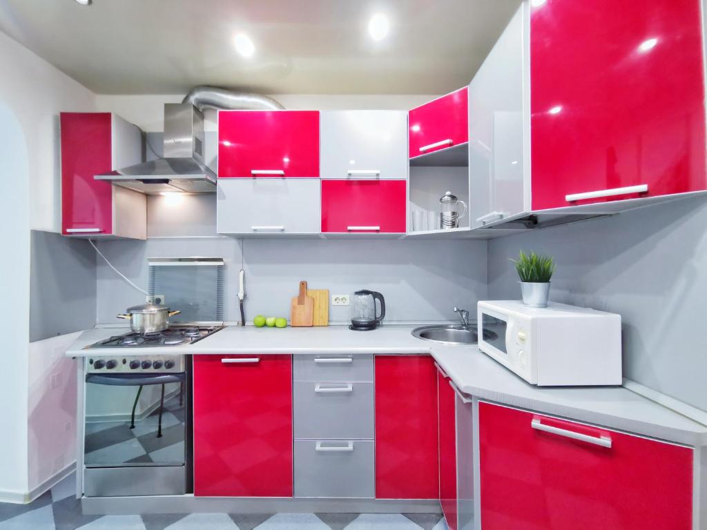 ヤロスラヴリにあるApart-Comfort Yangshuoの赤白のキッチン(赤いキャビネット付)