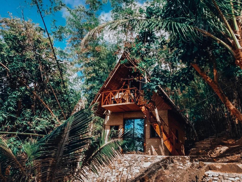 a cabin in the woods with a wooden deck at Cocovana Beach Resort in Busuanga