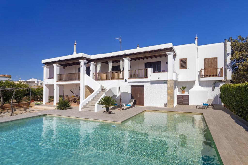 a villa with a swimming pool in front of a house at Huerta in San Antonio