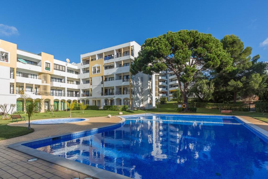 a swimming pool in front of a apartment building at Modern Top Floor Apartment 60m2 - Balcony with Pool & Sea View - Vilamoura in Vilamoura