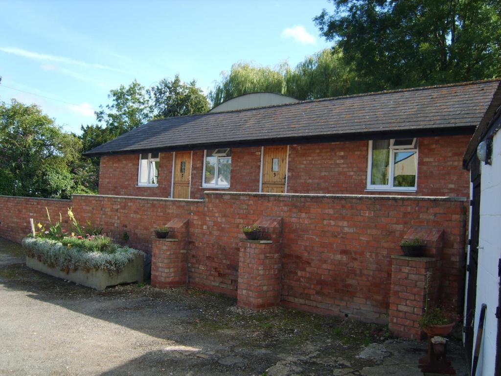 ein Backsteinhaus mit Pflanzen davor in der Unterkunft Church Farm in Stratford-upon-Avon