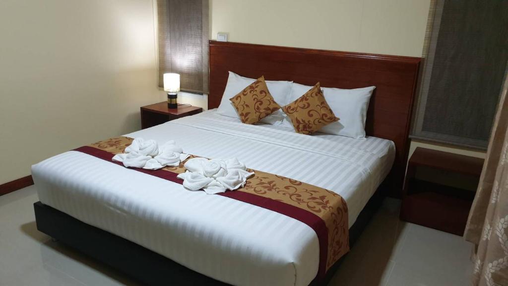 um quarto com uma cama grande com flores brancas em ฺBankunyaiy Resort em Ko Yao Yai