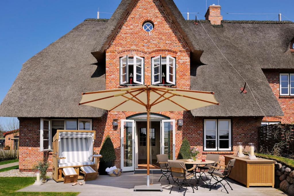 a large umbrella in front of a house at SalzWasserHerz Senhoog Luxury Holiday Homes ***** in Morsum