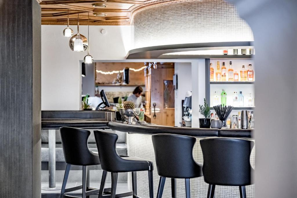 a bar with black chairs in a restaurant at Hotel Edelweiss & Gurgl in Obergurgl