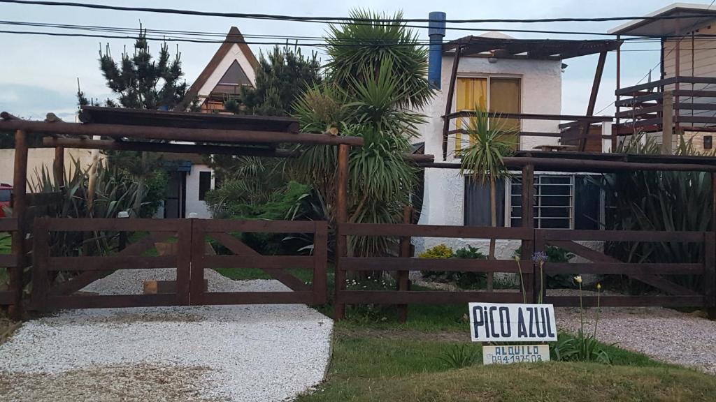 una valla de madera con un cartel delante de una casa en Pico Azul, en La Paloma