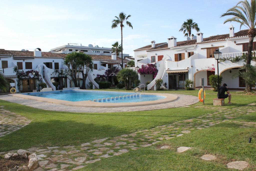 une villa avec une piscine en face d'un bâtiment dans l'établissement 150 Tropicana Park - Deniasol, à Dénia