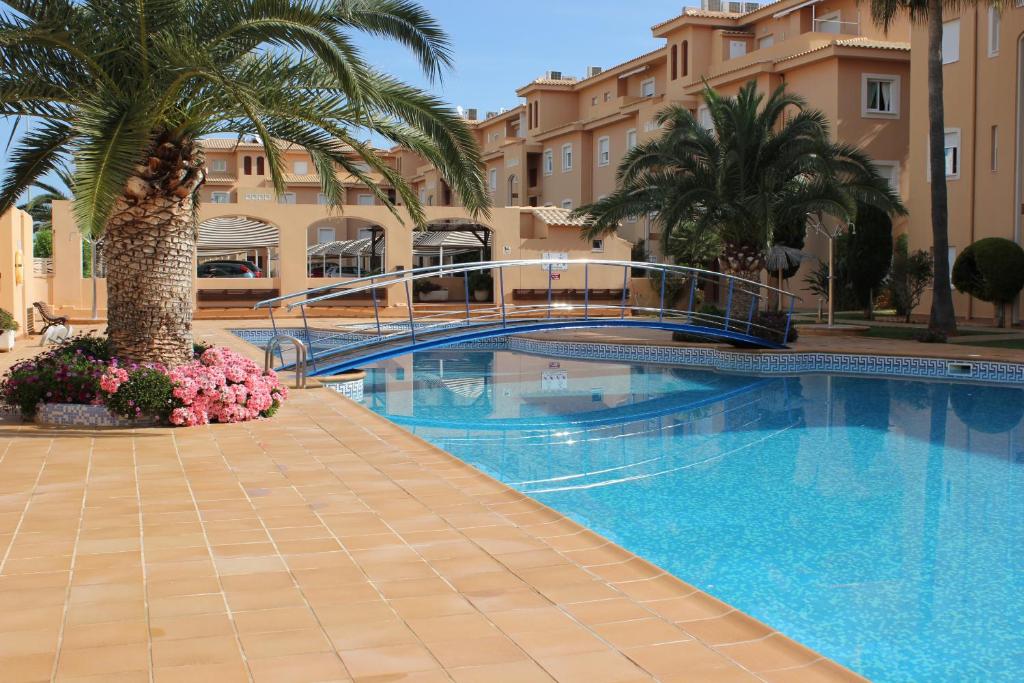 - une piscine avec un pont et des palmiers dans l'établissement 187 Palm Beach - Deniasol, à Dénia
