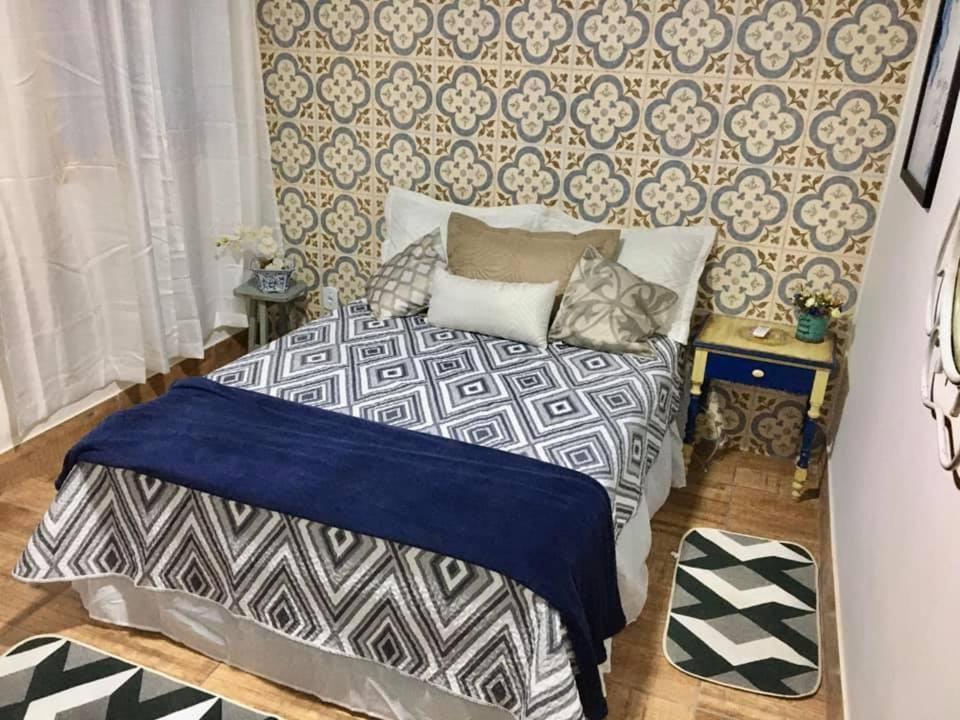 1 dormitorio con cama y pared con estampados en Chalé Recanto dos Anjos Arraial do Cabo, en Arraial do Cabo