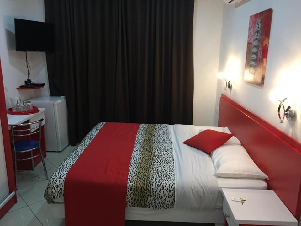 a bedroom with a bed with a red head board at Reno's Guest House in Birżebbuġa