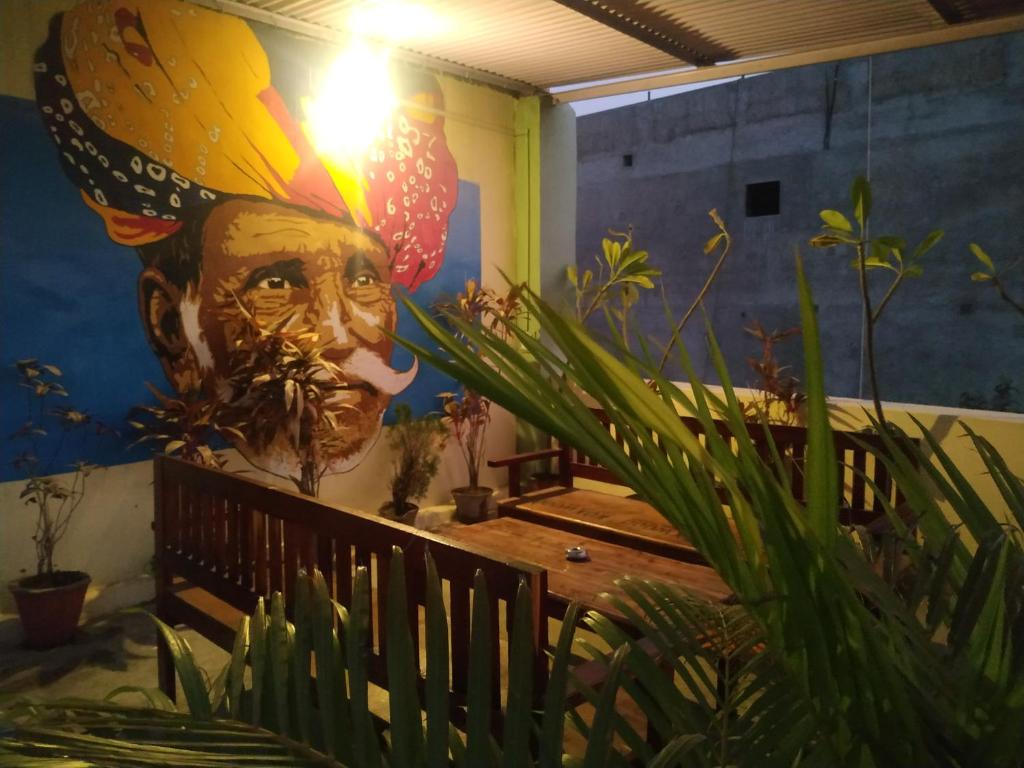 Mural człowieka z kapeluszem na ścianie w obiekcie Keshav Palace w mieście Pushkar