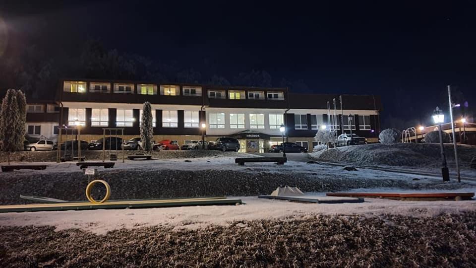 a building at night with snow in front of it at Hotel Hrádok in Jelšava