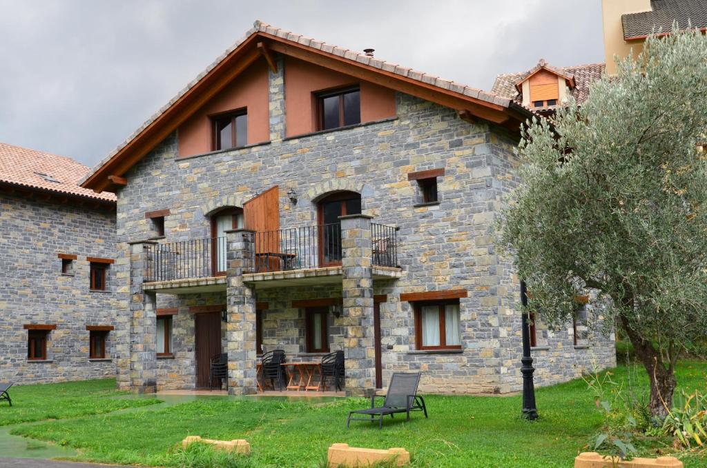 un gran edificio de piedra con un balcón lateral en Casas la Ribera Ordesa en Escalona