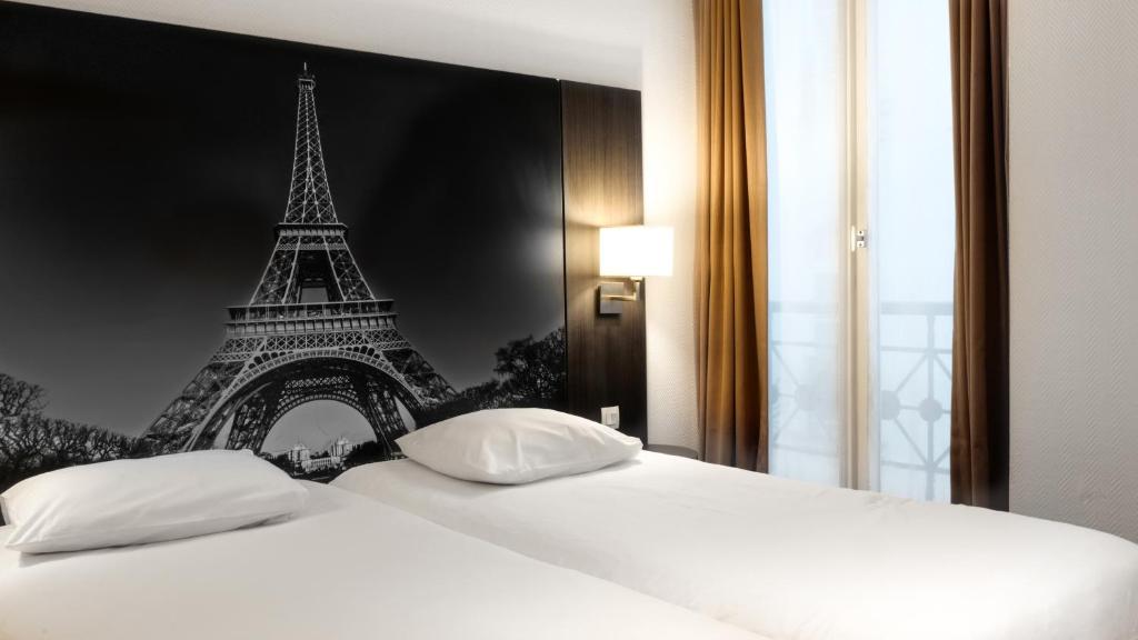 パリにあるホテル ヴィクトリアのエッフェル塔のあるベッドルーム1室が備わります。