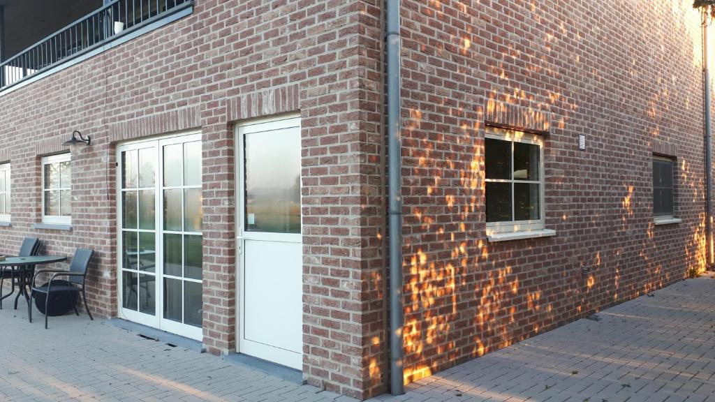 a brick building with a white door and windows at Klein Cambron in Hulst