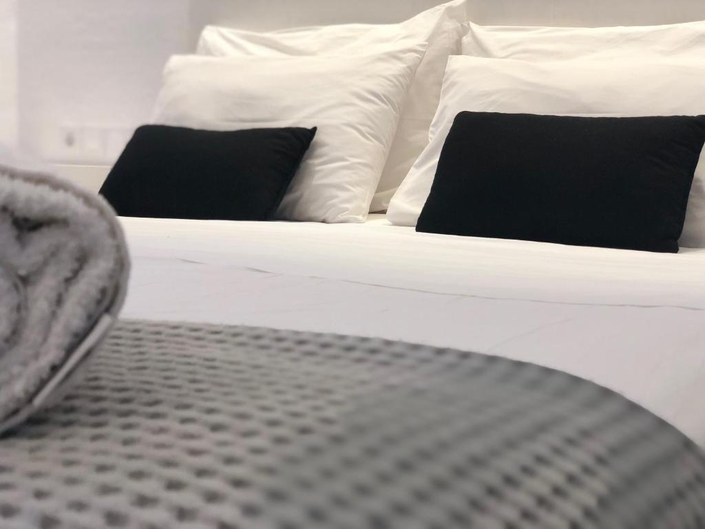 a bed with black and white pillows on it at Hippocampus Hotel in Naousa