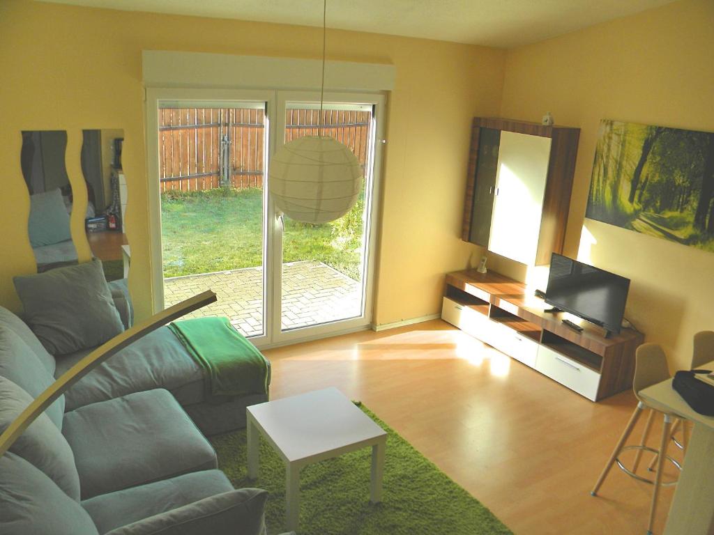 uma sala de estar com um sofá e uma televisão em Business Apartment/Ferienwohnung (z. CGN/FFM) em Ellenhausen