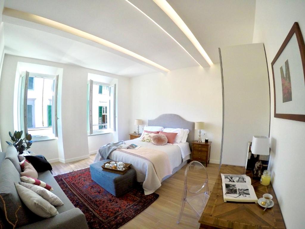 een witte slaapkamer met een bed en een bank bij NR8 - Santa Croce Apartment in Florence