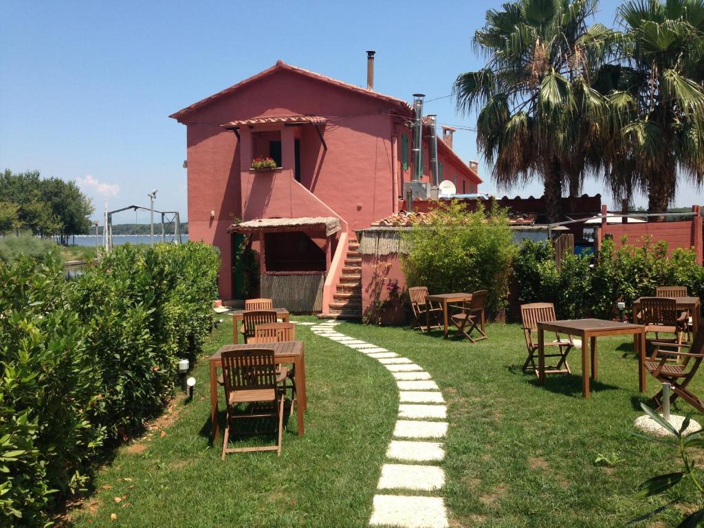 a house with chairs and tables in the grass at Proprietà Scalfati in Sabaudia