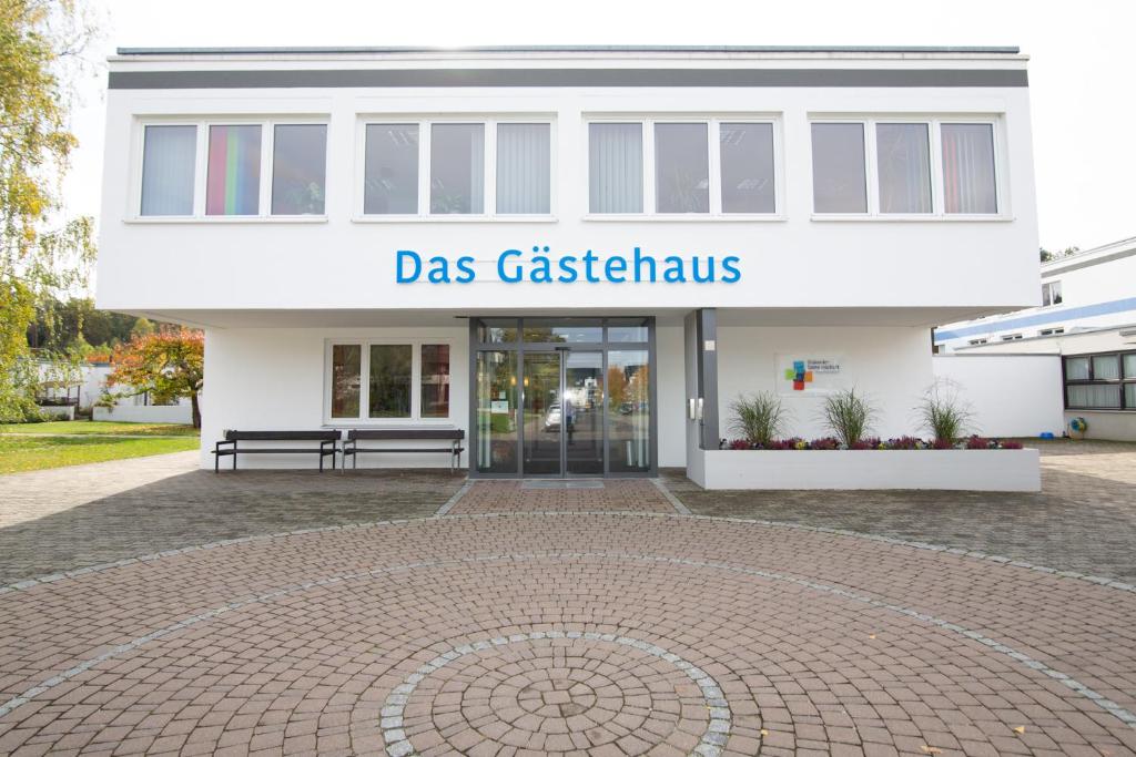 Un bâtiment blanc avec un panneau indiquant la catastrophe de classe dans l'établissement Das Gästehaus Puschendorf, à Puschendorf