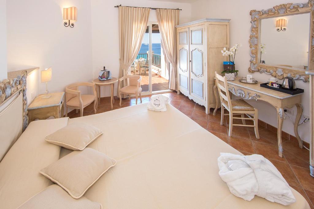 Postel nebo postele na pokoji v ubytování COLONNA GRAND HOTEL CAPO TESTA, a Colonna Luxury Beach Hotel, Santa Teresa Sardegna