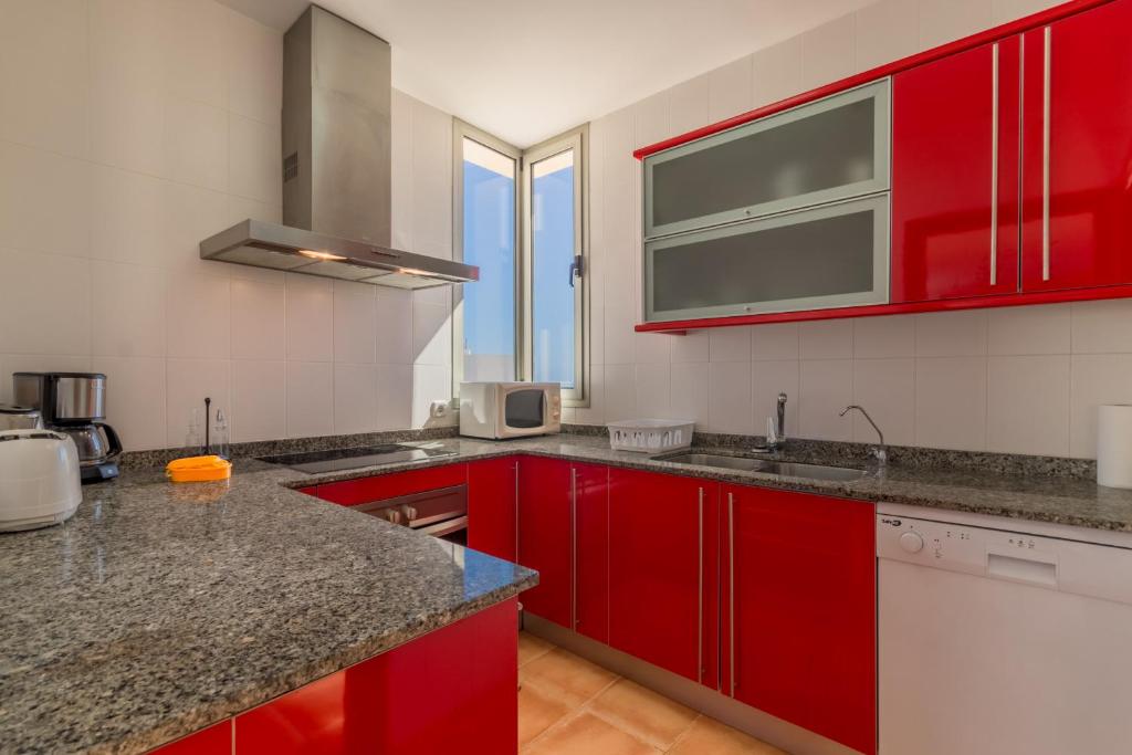 a kitchen with red cabinets and a counter top at Cala Murada - 2778-83 Mallorca in Cala Murada