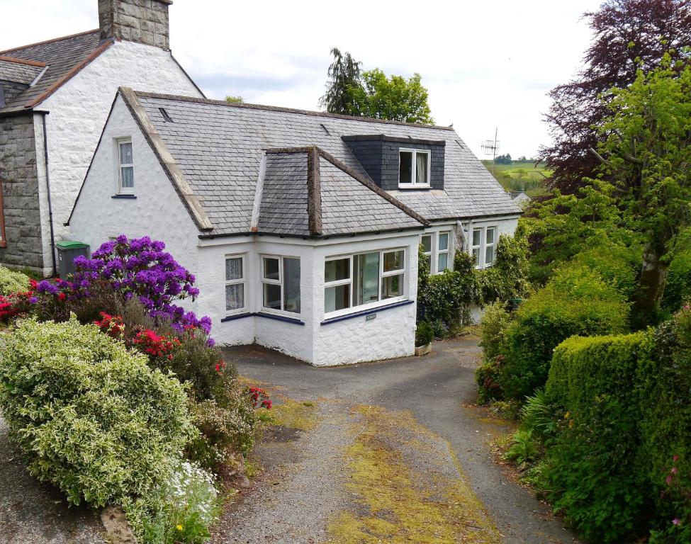 una casa blanca con una entrada delante de ella en Rowan Cottage en New Galloway