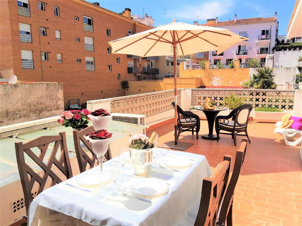 a table and chairs with an umbrella on a patio at APARTAMENTO ISAMAR in Calella
