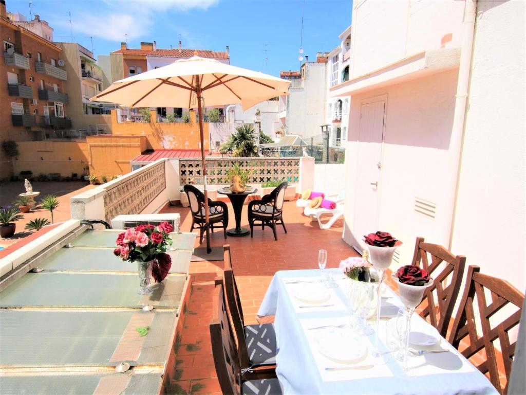 a balcony with a table and an umbrella at APARTAMENTO ISAMAR in Calella