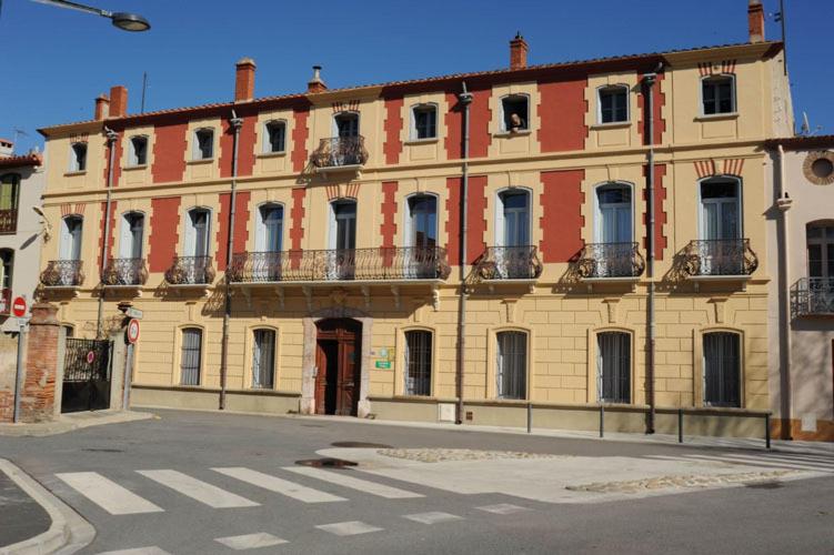 un grand bâtiment sur le côté d'une rue dans l'établissement Les Buis, à Ille-sur-Têt