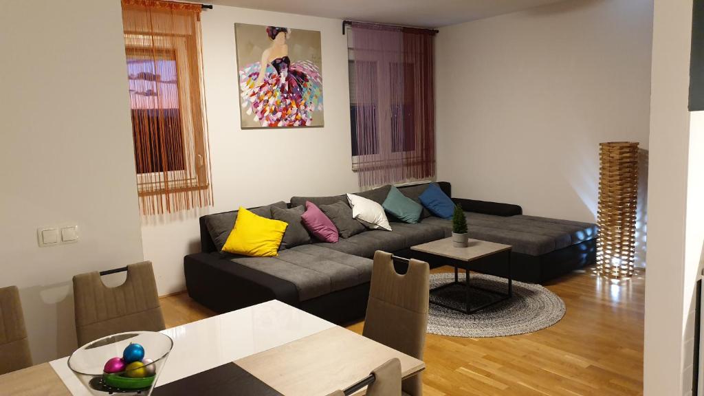 ein Wohnzimmer mit einem Sofa und einem Tisch in der Unterkunft Apartman Zoe in Zagreb