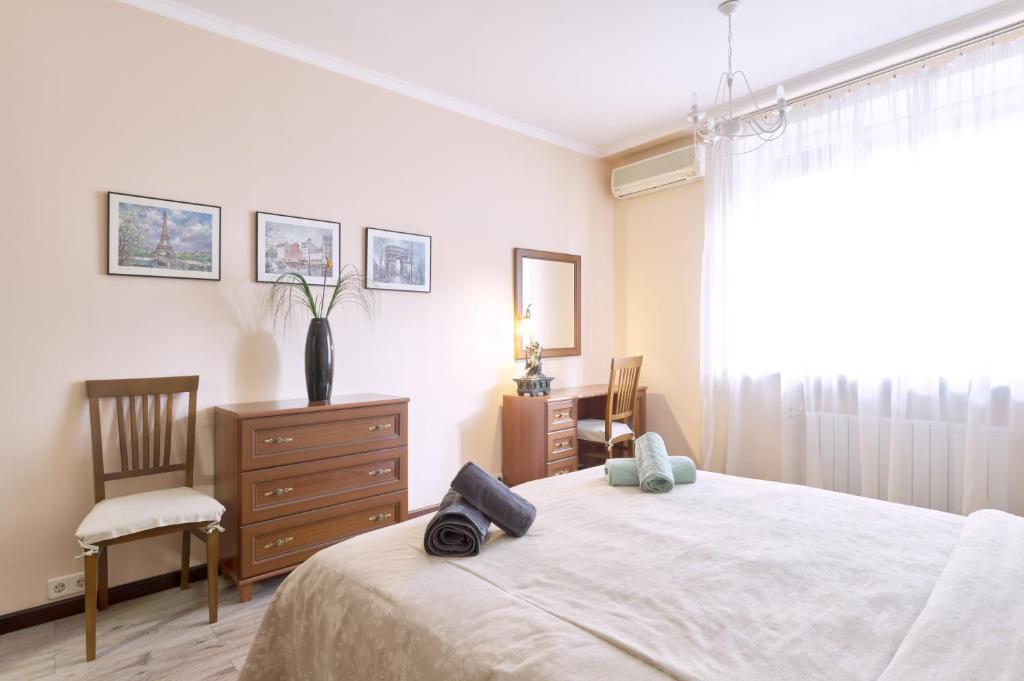 ein Schlafzimmer mit einem Bett, einer Kommode und einem Fenster in der Unterkunft 1BR apartment in the old city center (Kyïv) in Kiew