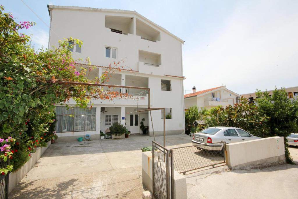 a white house with a car parked in front of it at Apartments Marika in Drasnice