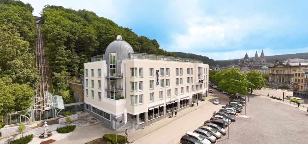 a large white building with a large clock on top of it at Radisson BLU Palace Hotel in Spa