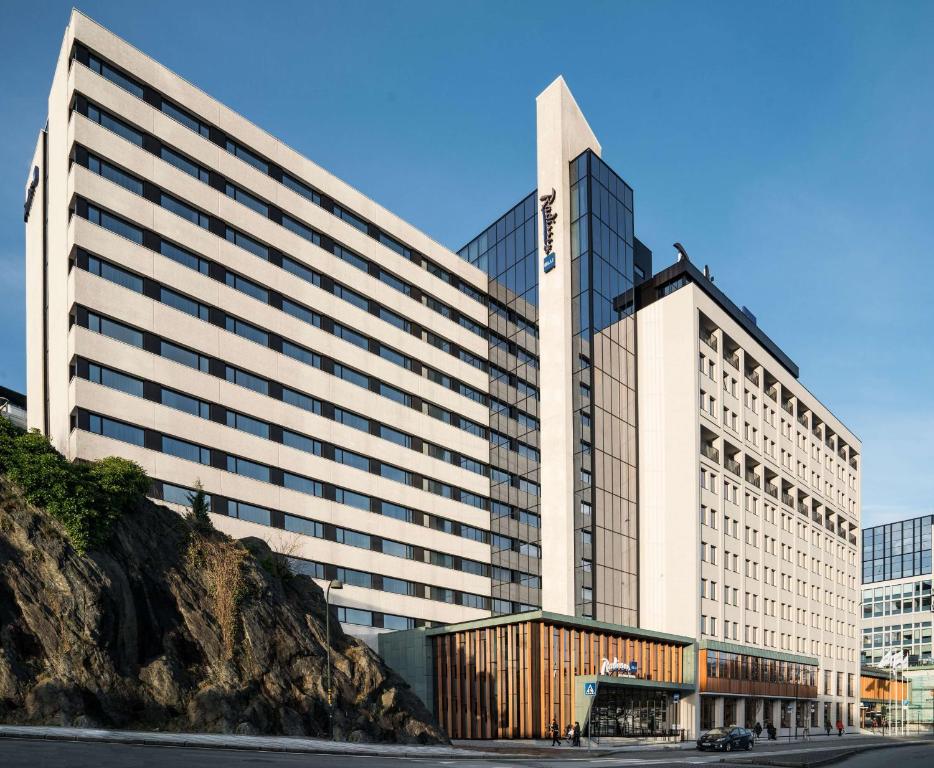 a large white building with a mountain in front of it at Radisson Blu Atlantic Hotel, Stavanger in Stavanger