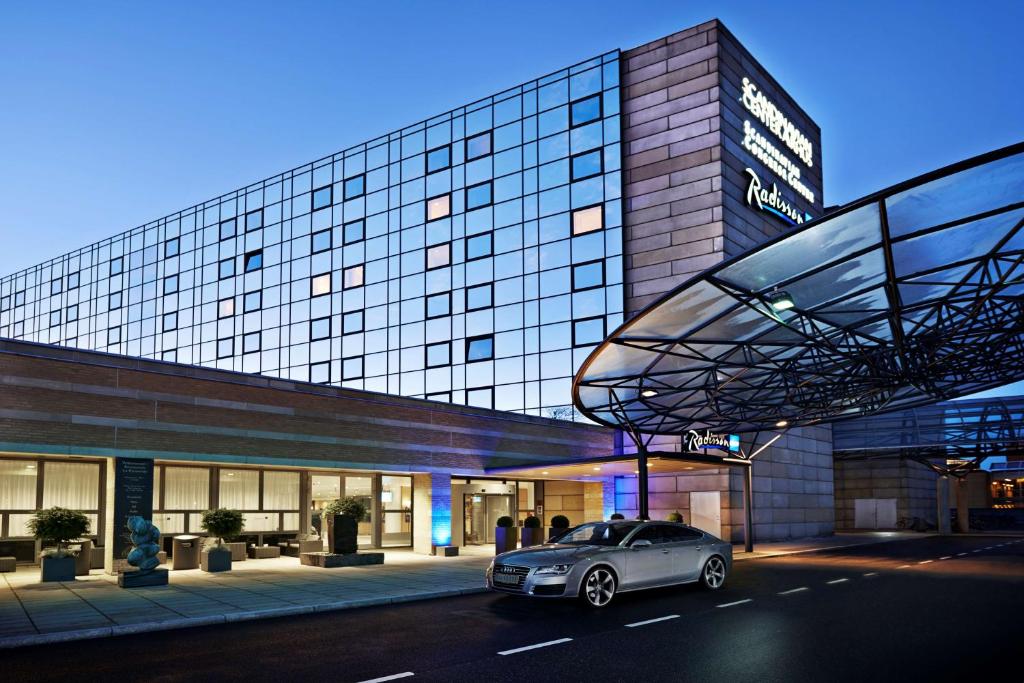 een auto geparkeerd voor een gebouw bij Radisson Blu Scandinavia Hotel Aarhus in Aarhus