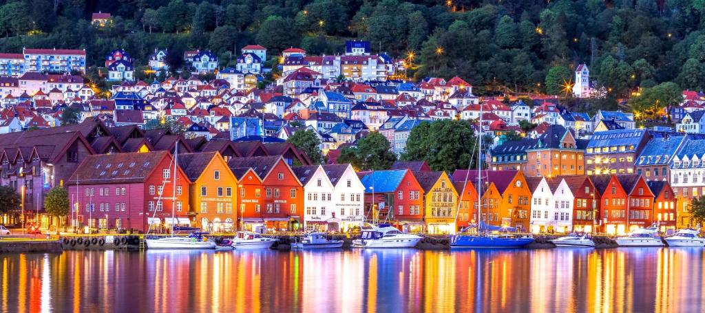 une ville de nuit avec des bateaux dans l'eau dans l'établissement Radisson Blu Royal Hotel, Bergen, à Bergen