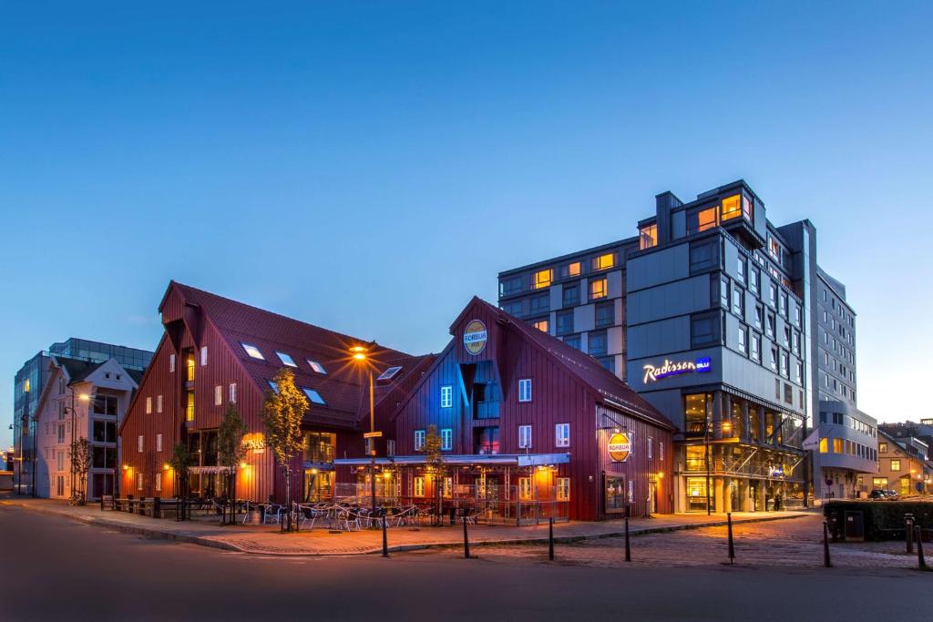 un groupe de bâtiments de nuit dans une ville dans l'établissement Radisson Blu Hotel Tromsø, à Tromsø