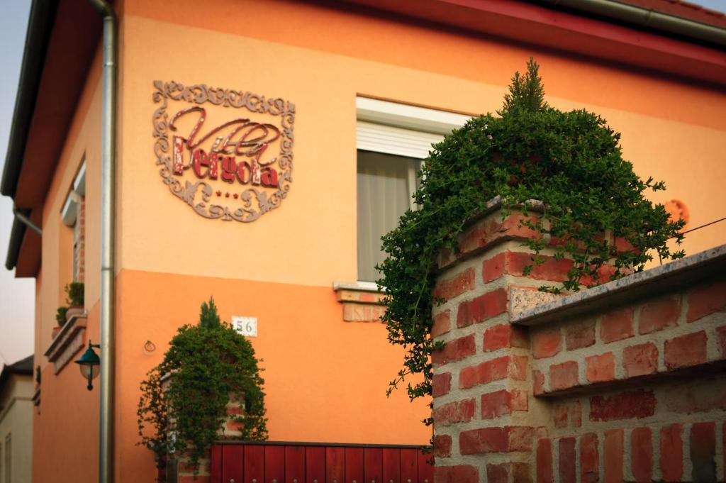 un edificio con un cartel en el costado en La Villa Pergola, en Szentgotthárd
