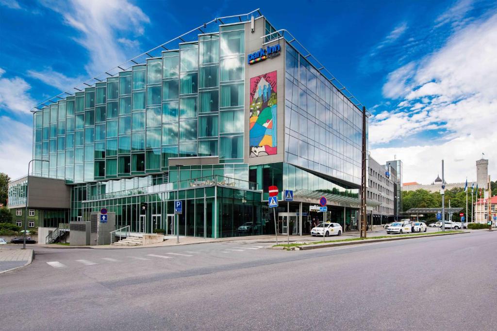 a large glass building on the corner of a street at Park Inn by Radisson Meriton Conference & Spa Hotel Tallinn in Tallinn